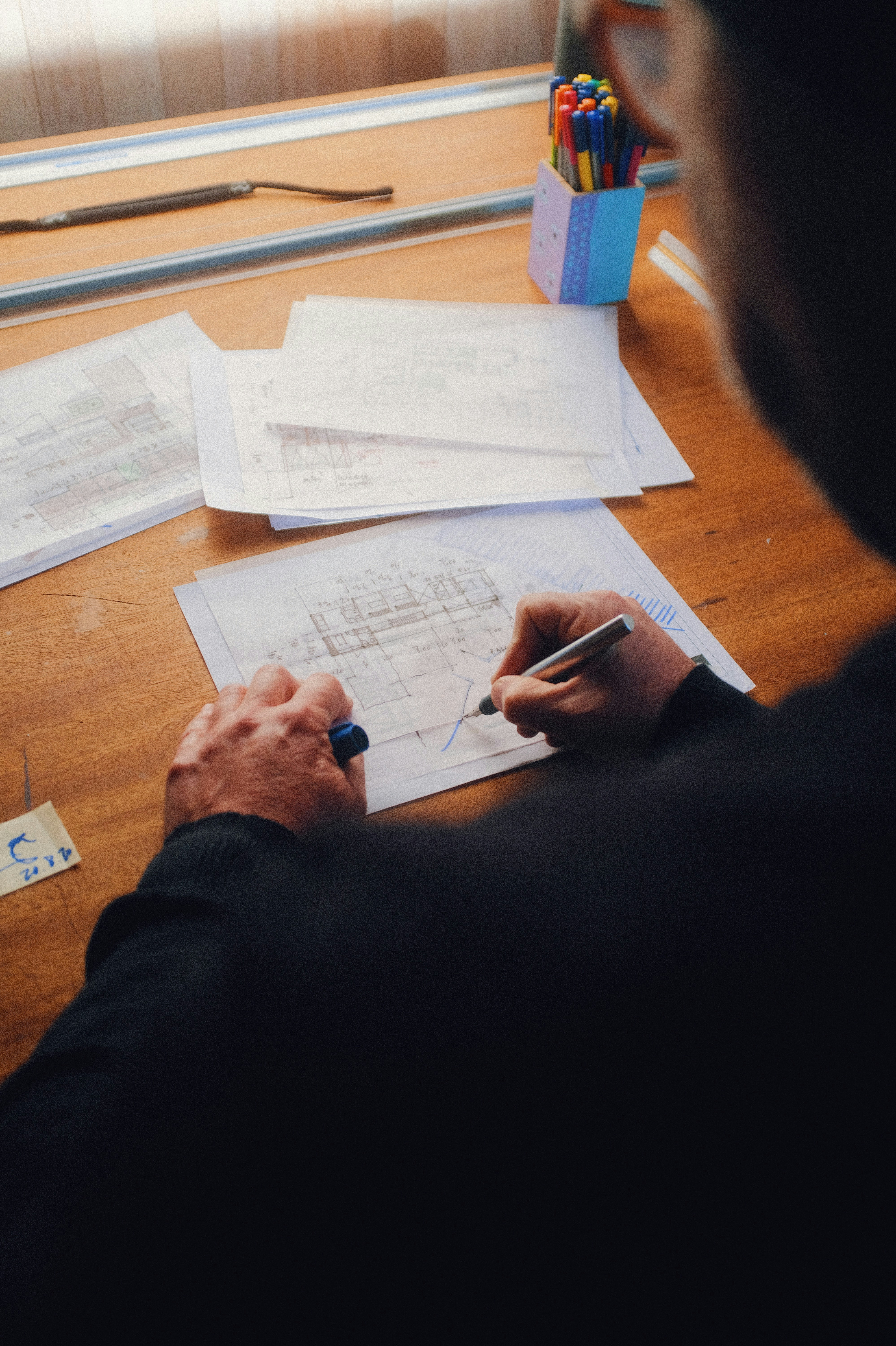 An individual working on architectural drawings